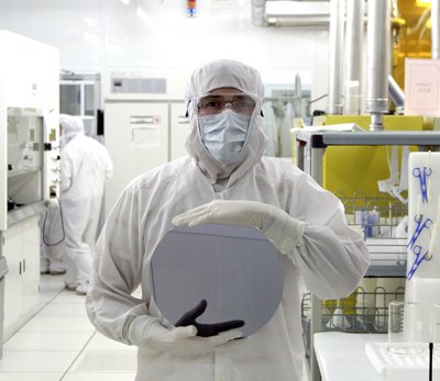 Cleanroom  technician holding semiconductor wafer